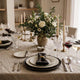 Proper dinner table setting with plates, flatware, and glassware